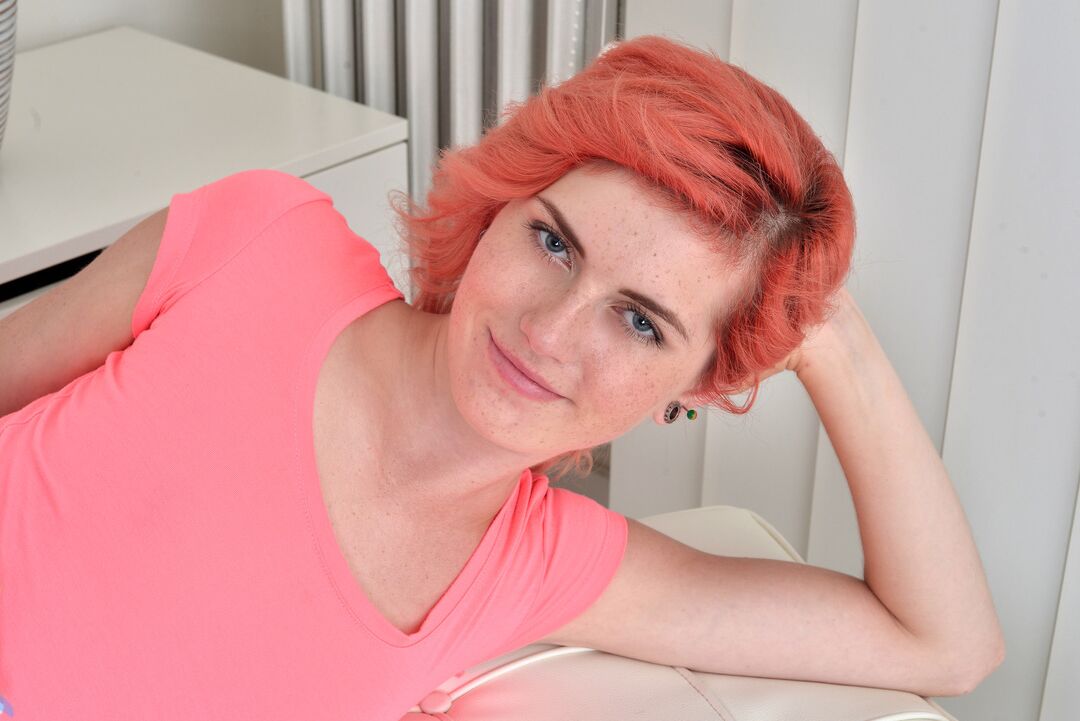 16P Das schlanke Mädchen Anna Swix trägt gefärbte Haare, während sie sich auf einer Massageliege auszieht