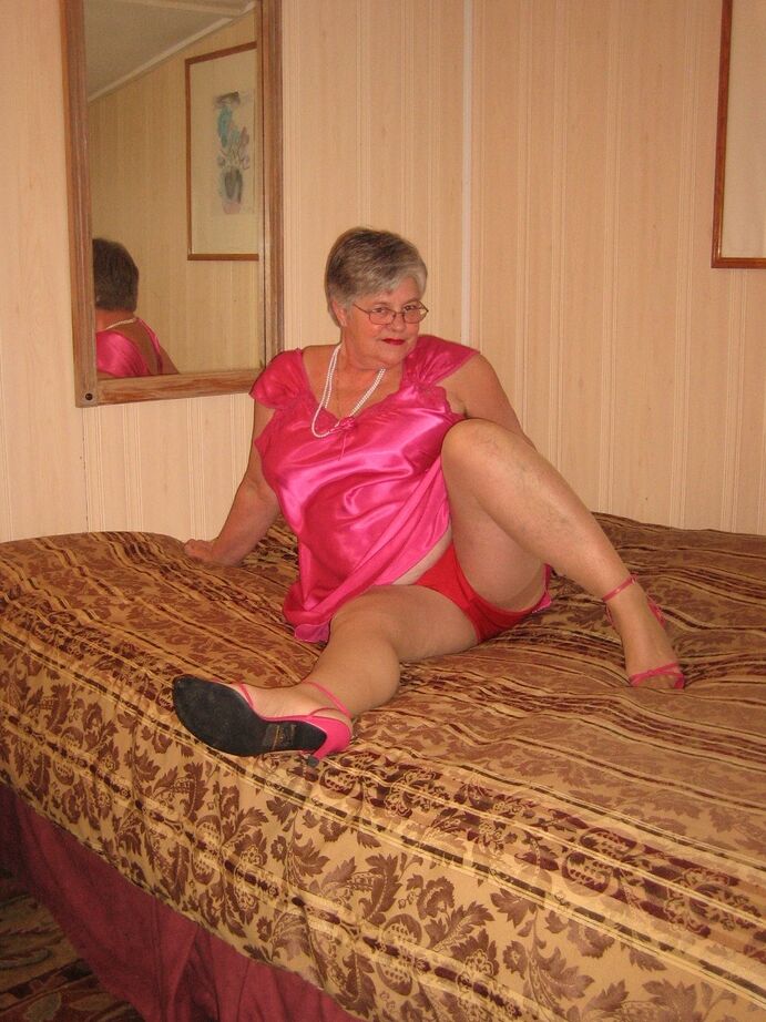 20P Silver haired nan Girdle Goddess pulls her hose down around her knees on a bed