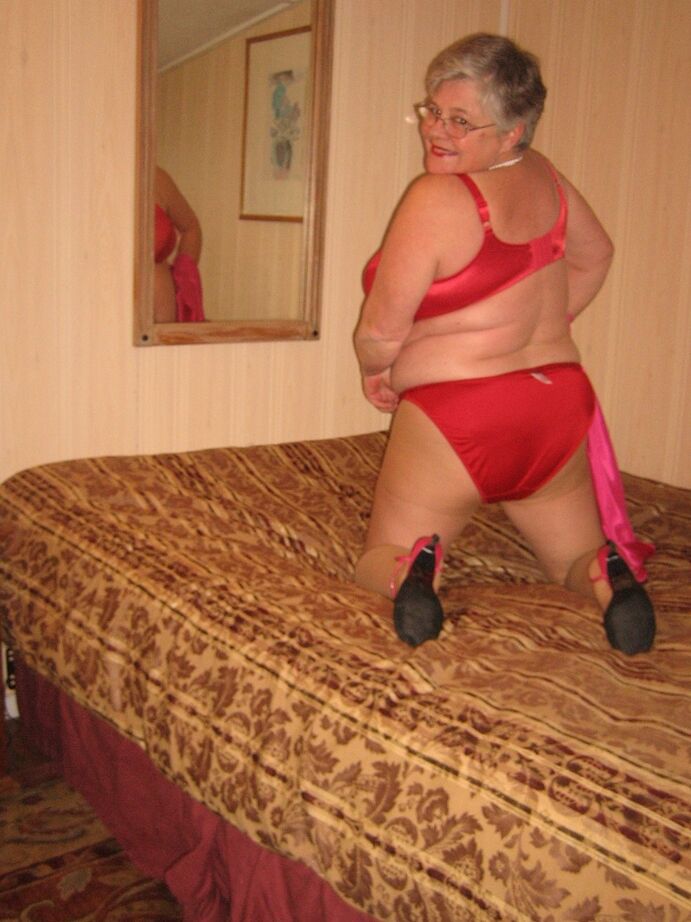 20P Silver haired nan Girdle Goddess pulls her hose down around her knees on a bed