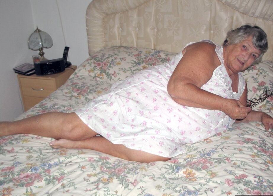 20P Old woman Grandma Libby grabs her fat roll after getting naked on a bed