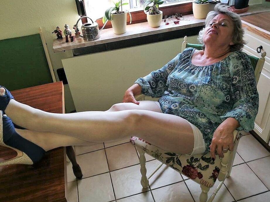 20P Old woman Caro pulls down her pantyhose in high heels at kitchen table