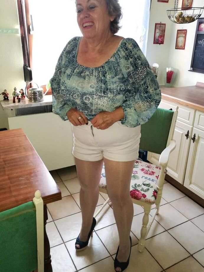 20P Old woman Caro pulls down her pantyhose in high heels at kitchen table