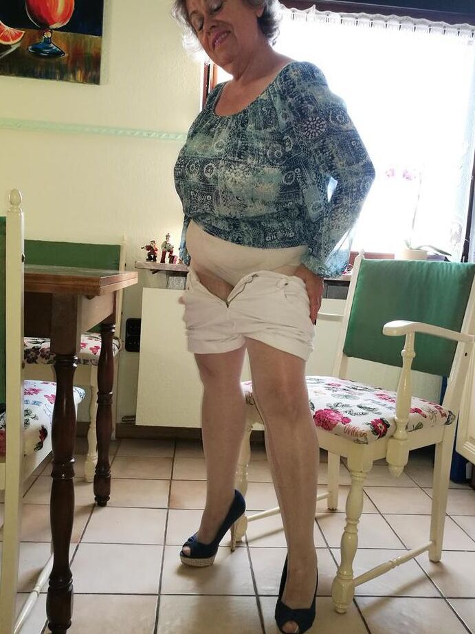 20P Old woman Caro pulls down her pantyhose in high heels at kitchen table