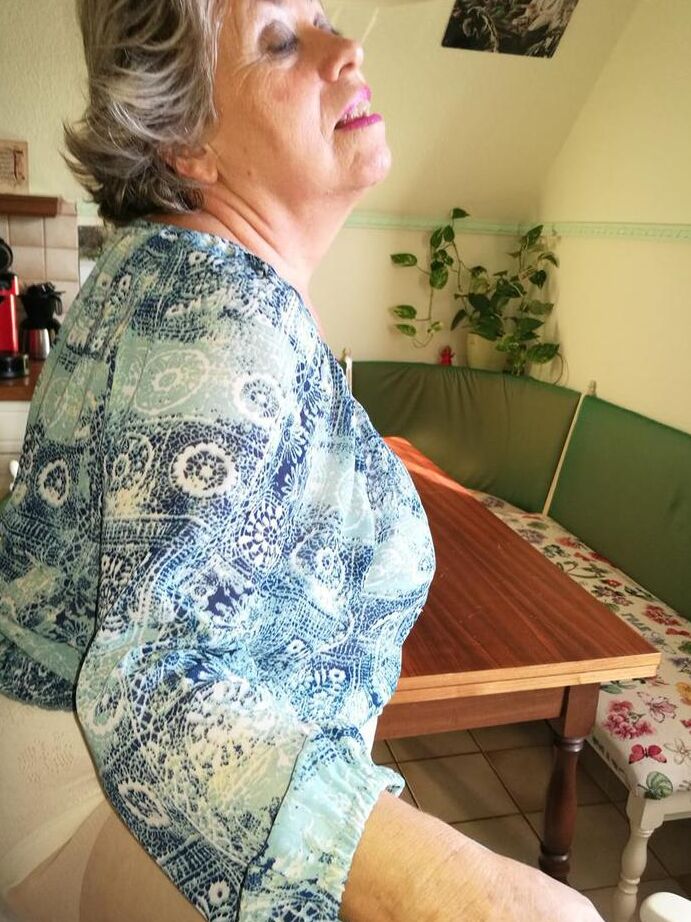 20P Old woman Caro pulls down her pantyhose in high heels at kitchen table