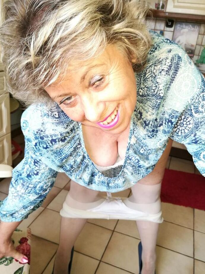 20P Old woman Caro pulls down her pantyhose in high heels at kitchen table