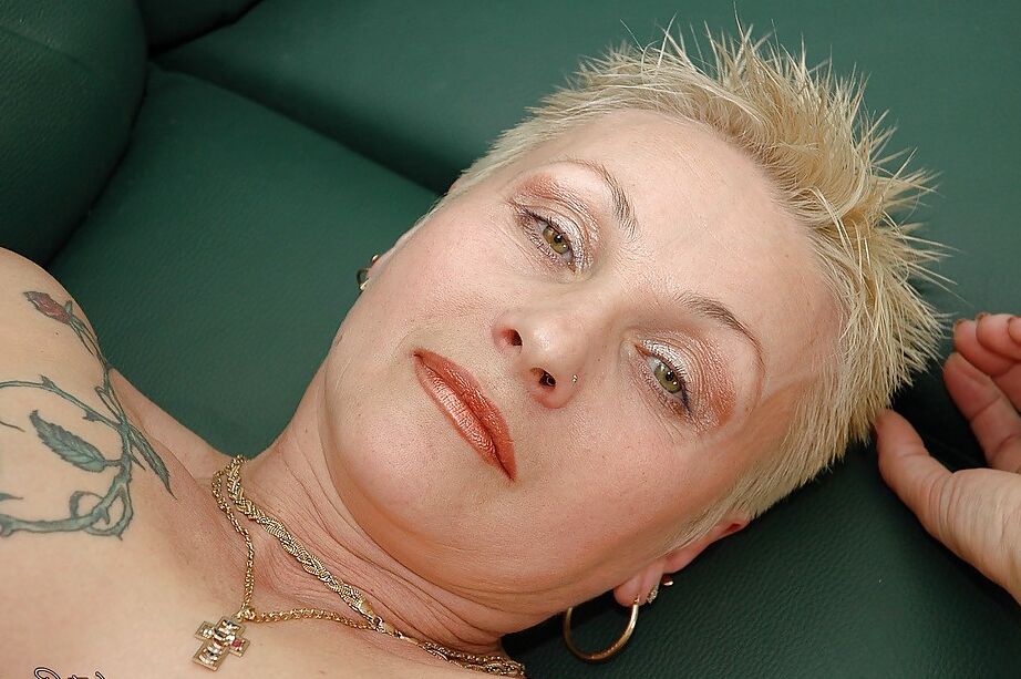 16P Mamie tatouée aux cheveux courts avec des tétons percés enlevant sa lingerie