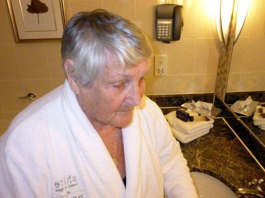 20P Fat nan Grandma Libby removes a bathrobe to pose nude in a cupless bra