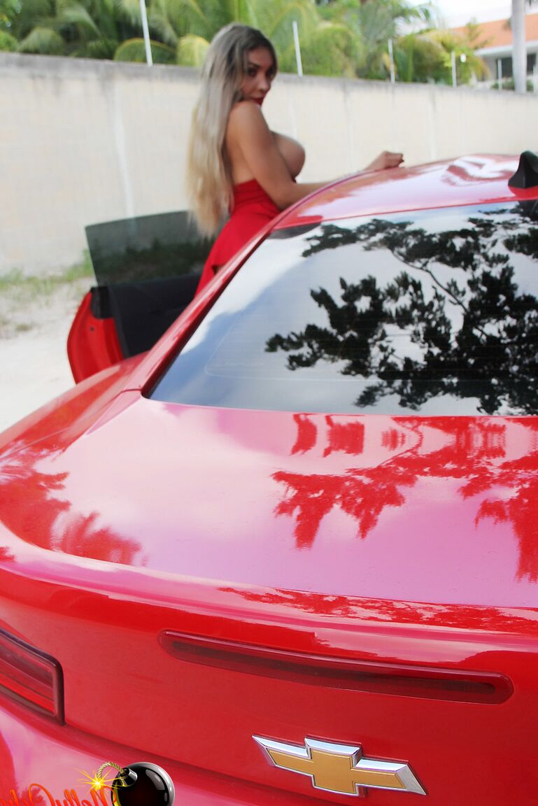 15P Eine blonde Bombe mit tollen Titten posiert auf einem Sportwagen