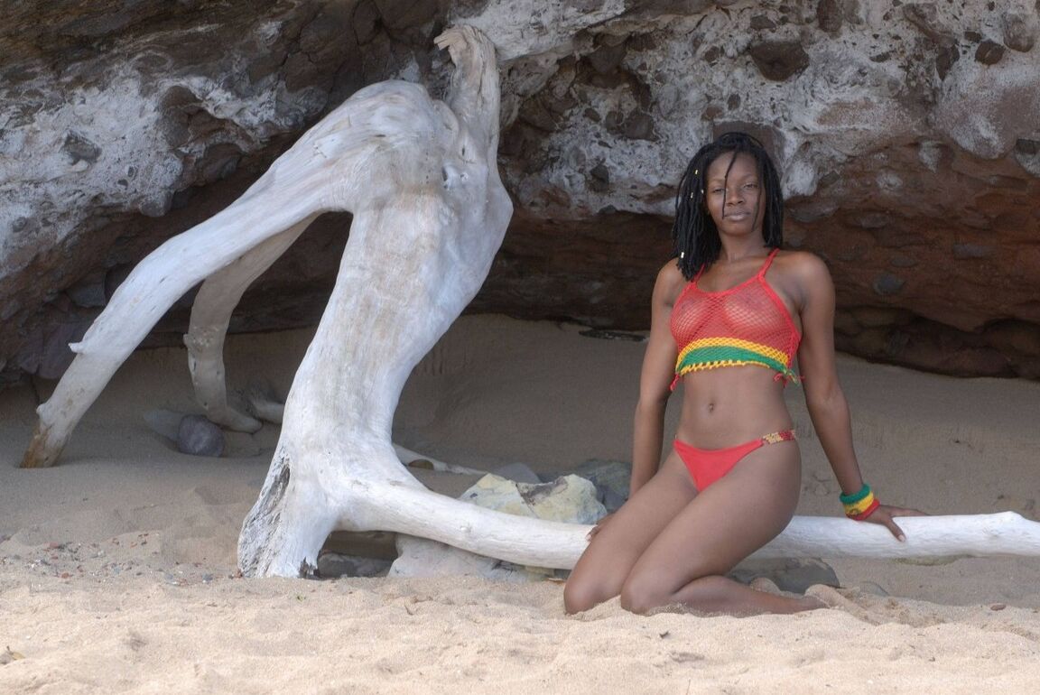 16P The beautiful mixed girl plays with an old tree on a carribbean beach