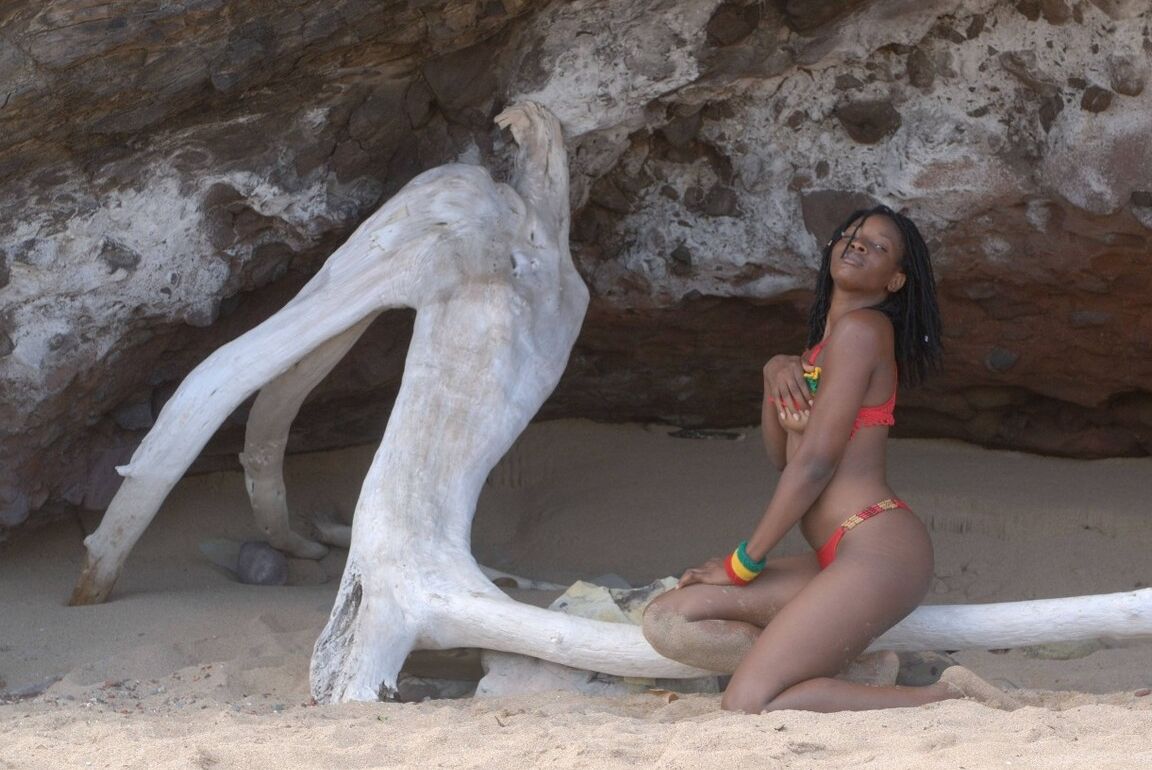 16P The beautiful mixed girl plays with an old tree on a carribbean beach