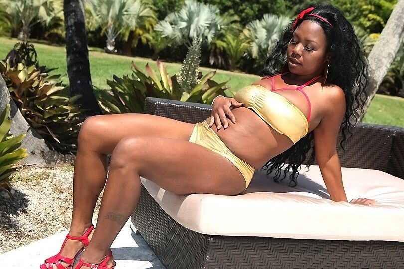 16P Une fille ébène potelée avec des cruches massives huile ses courbes en plein air