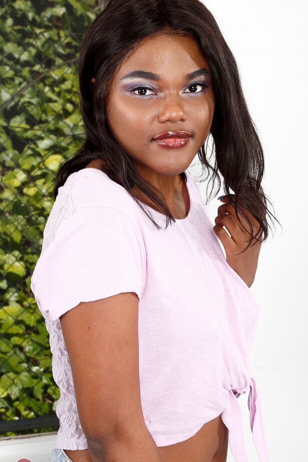 16P Ebony chick with small tits frees her bald cunt and bare ass from jean shorts