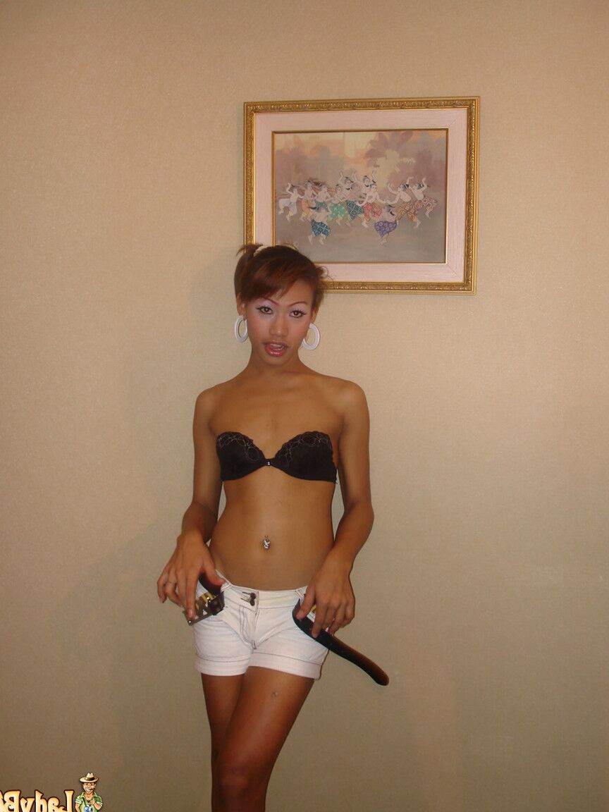 21P Die schlanke Transe Monika zieht ihre Kleidung aus und bläst auf einem Bett einen