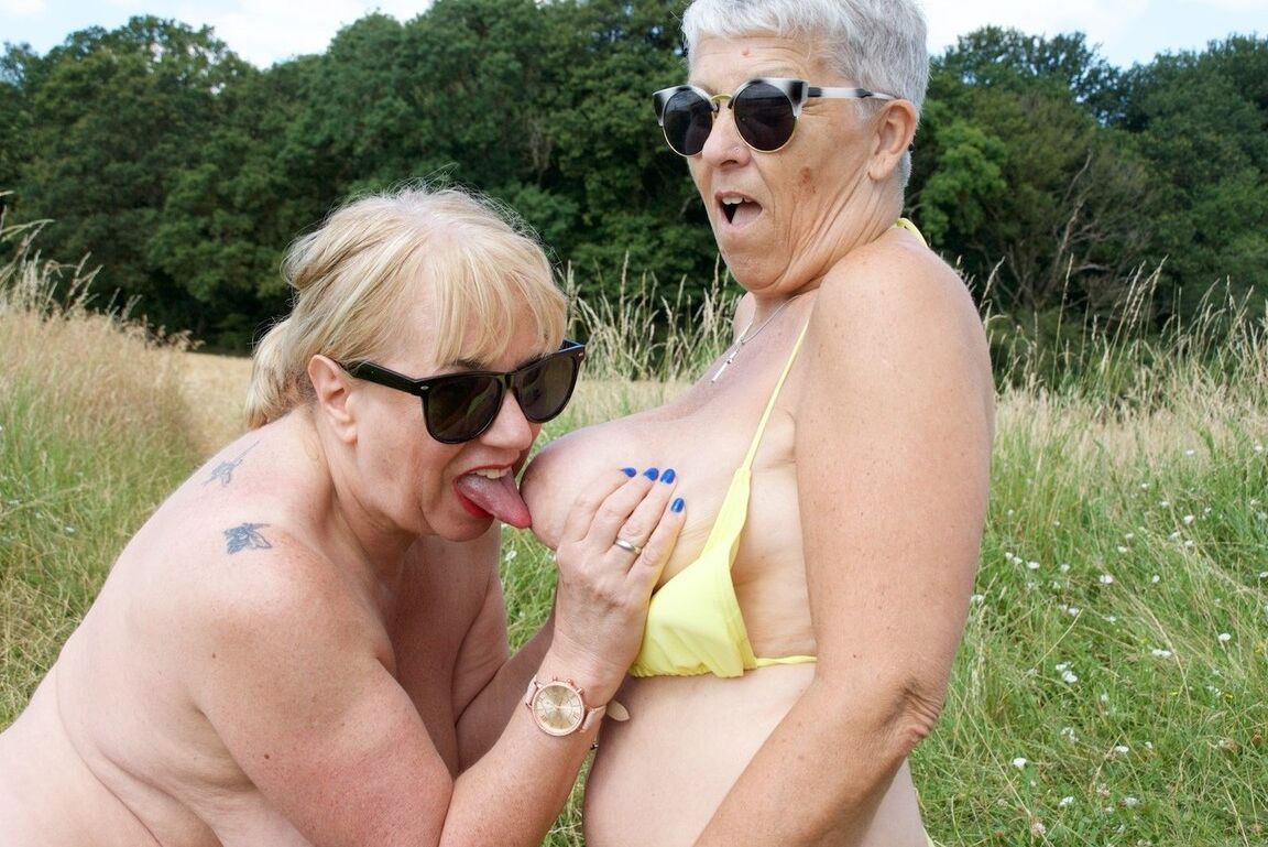 20P Aged lesbians have sexual relations on a blanket in a field in sunglasses
