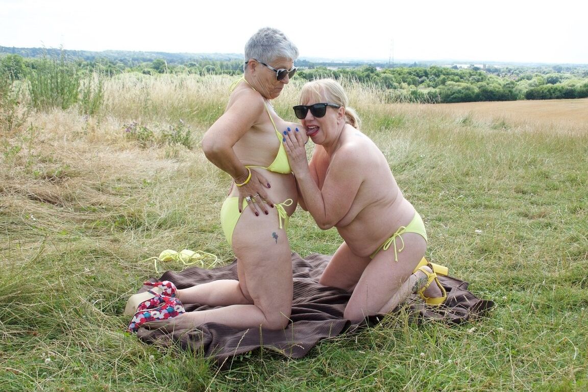20P Aged lesbians have sexual relations on a blanket in a field in sunglasses
