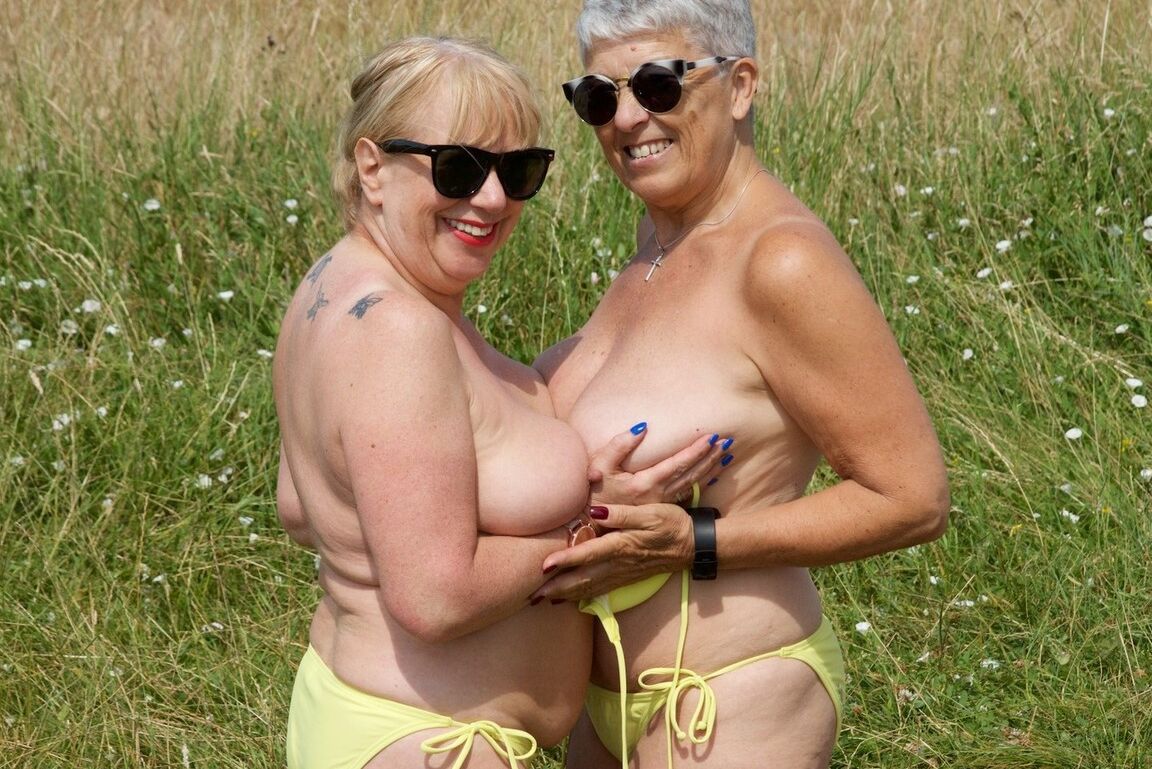 20P Aged lesbians have sexual relations on a blanket in a field in sunglasses