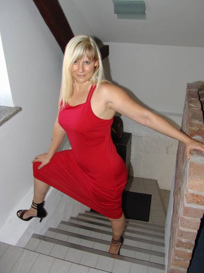 Die 20P blonde Amateurin Sweet Susi zieht ihr langes rotes Kleid aus, um nackt zu posieren