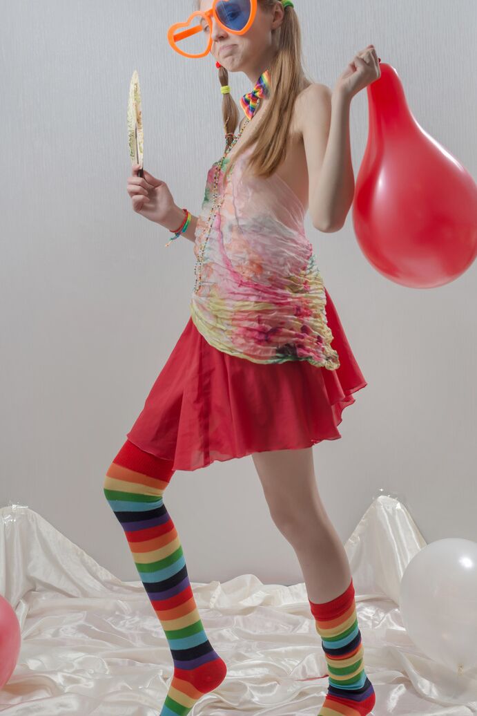 20P Uma adolescente magrinha com tranças e meias multicoloridas tira a roupa