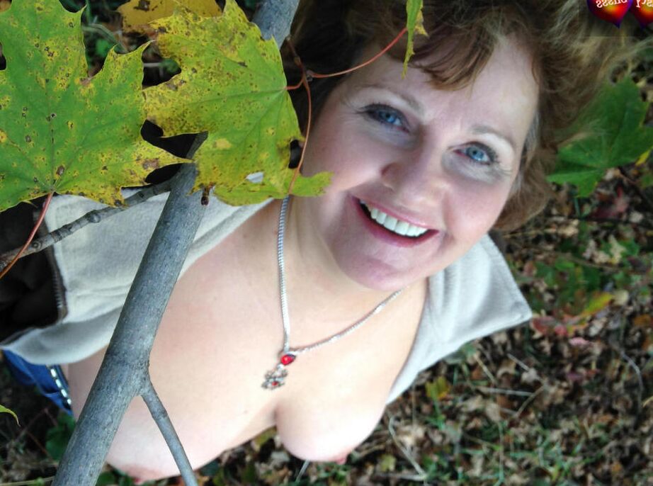 20P La mujer mayor Busty Bliss expone sus grandes tetas naturales debajo de un árbol en el otoño