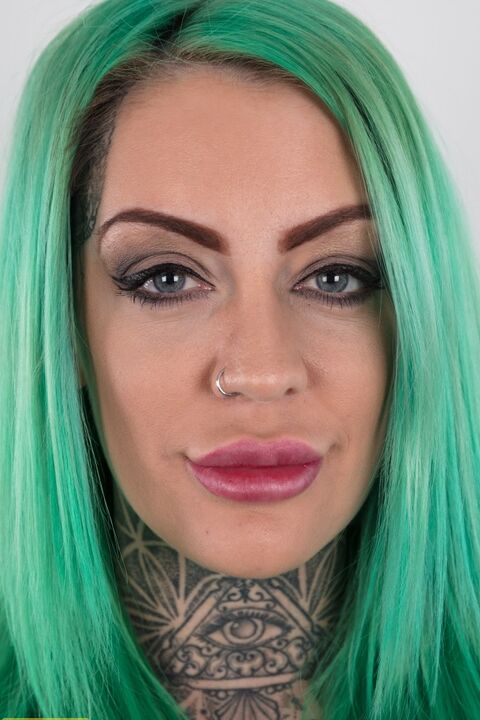 20P Une fille tatouée aux cheveux verts et aux tétons percés se tient nue après s'être déshabillée