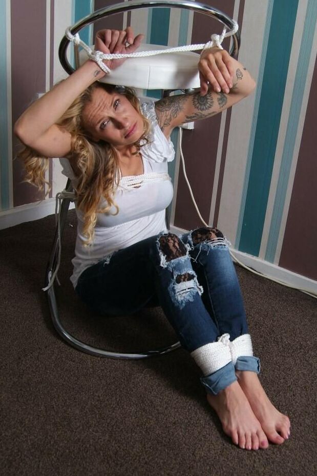 16P Fully clothed blonde Katie C struggles while restrained with rope bindings