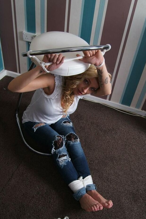 16P Fully clothed blonde Katie C struggles while restrained with rope bindings