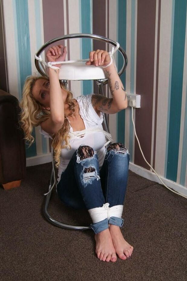 16P Fully clothed blonde Katie C struggles while restrained with rope bindings