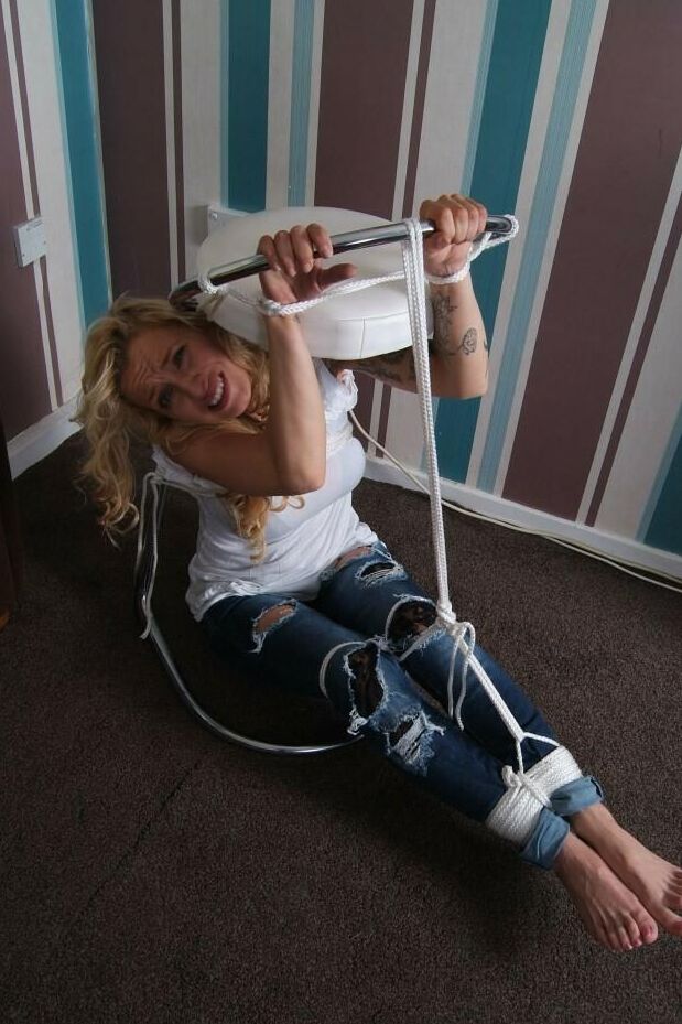 16P Fully clothed blonde Katie C struggles while restrained with rope bindings