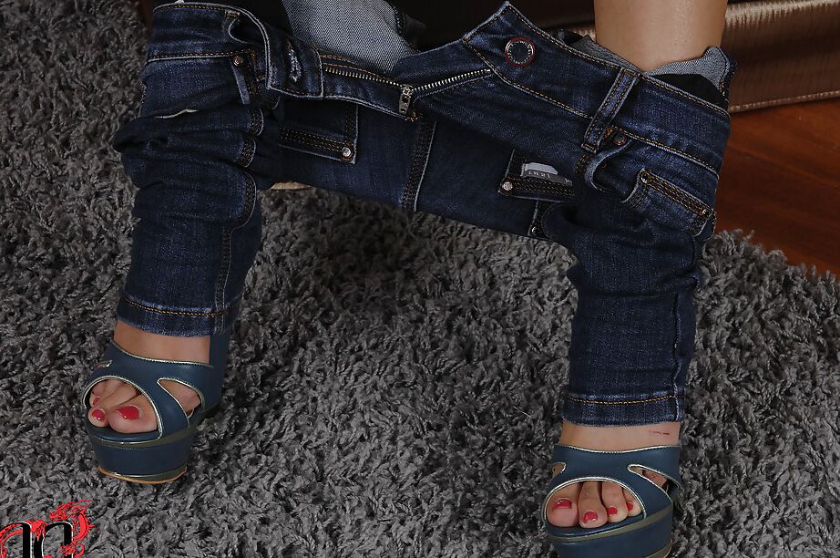 La modelo europea 16P Aurelly Rebel se quita los jeans para posar desnuda en una silla de cuero