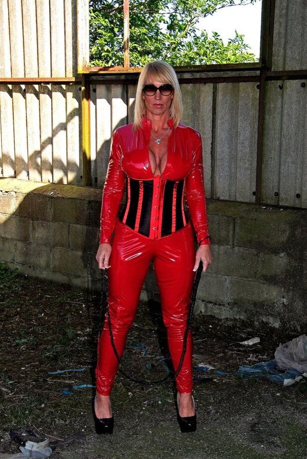 20P A loira madura e sexy Melody empunha um chicote enquanto abre o zíper de roupas de látex vermelho