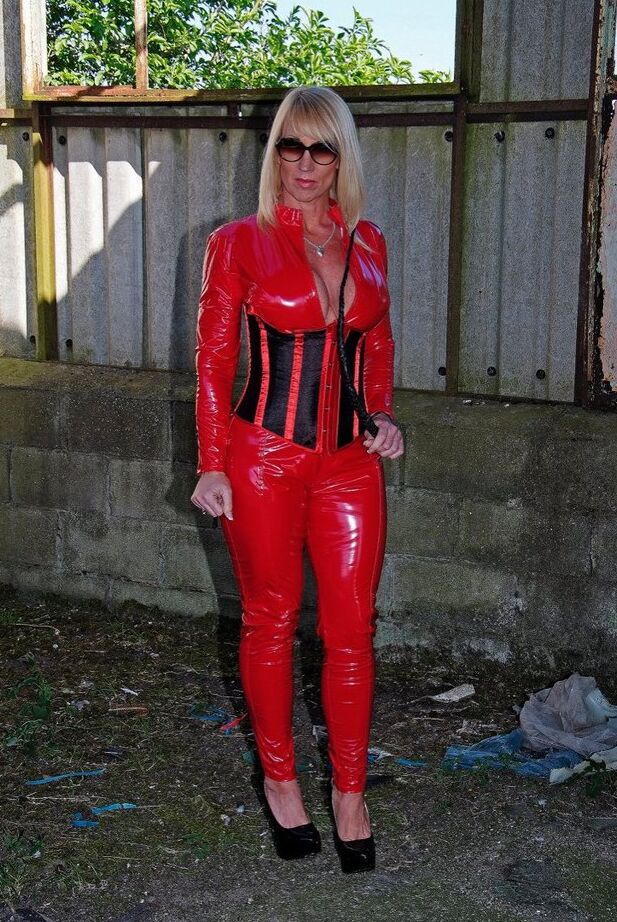 20P A loira madura e sexy Melody empunha um chicote enquanto abre o zíper de roupas de látex vermelho