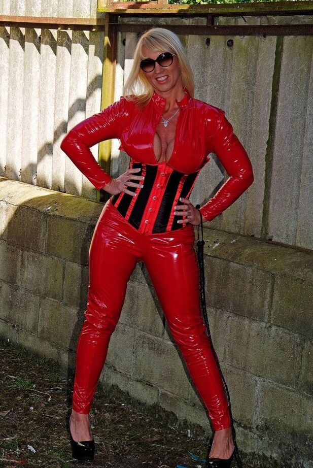 20P A loira madura e sexy Melody empunha um chicote enquanto abre o zíper de roupas de látex vermelho
