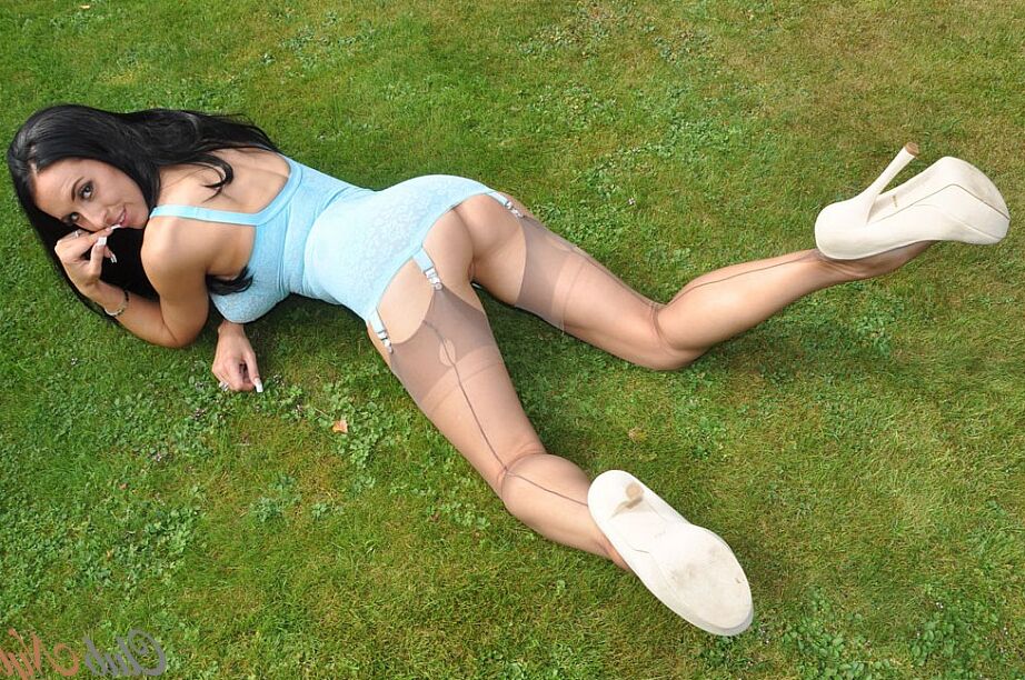 15P Busty MILF Lou Jenson mostra suas pernas vestidas de náilon e salto alto no gramado