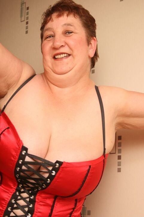 20P Overweight mature redhead Kinky Carol looses her large boobs from a corset