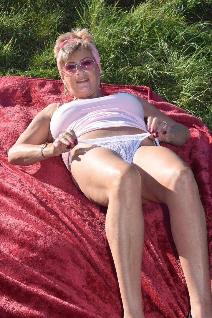 16P Older blonde Dimonty shows her natural tits while getting dressed in a field