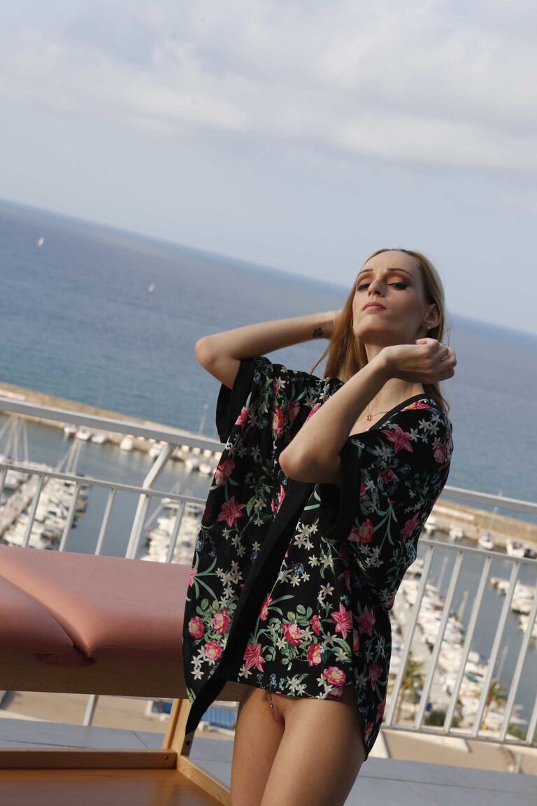 19P Erica Fontes is outside on the terrace exposing her fake boobs and slim body