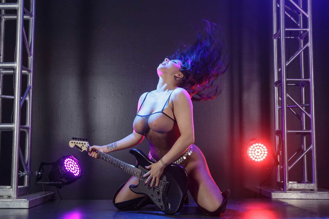 21P Busty MILF rock star Romi Rain strips on the stage & plays in fishnets & boots