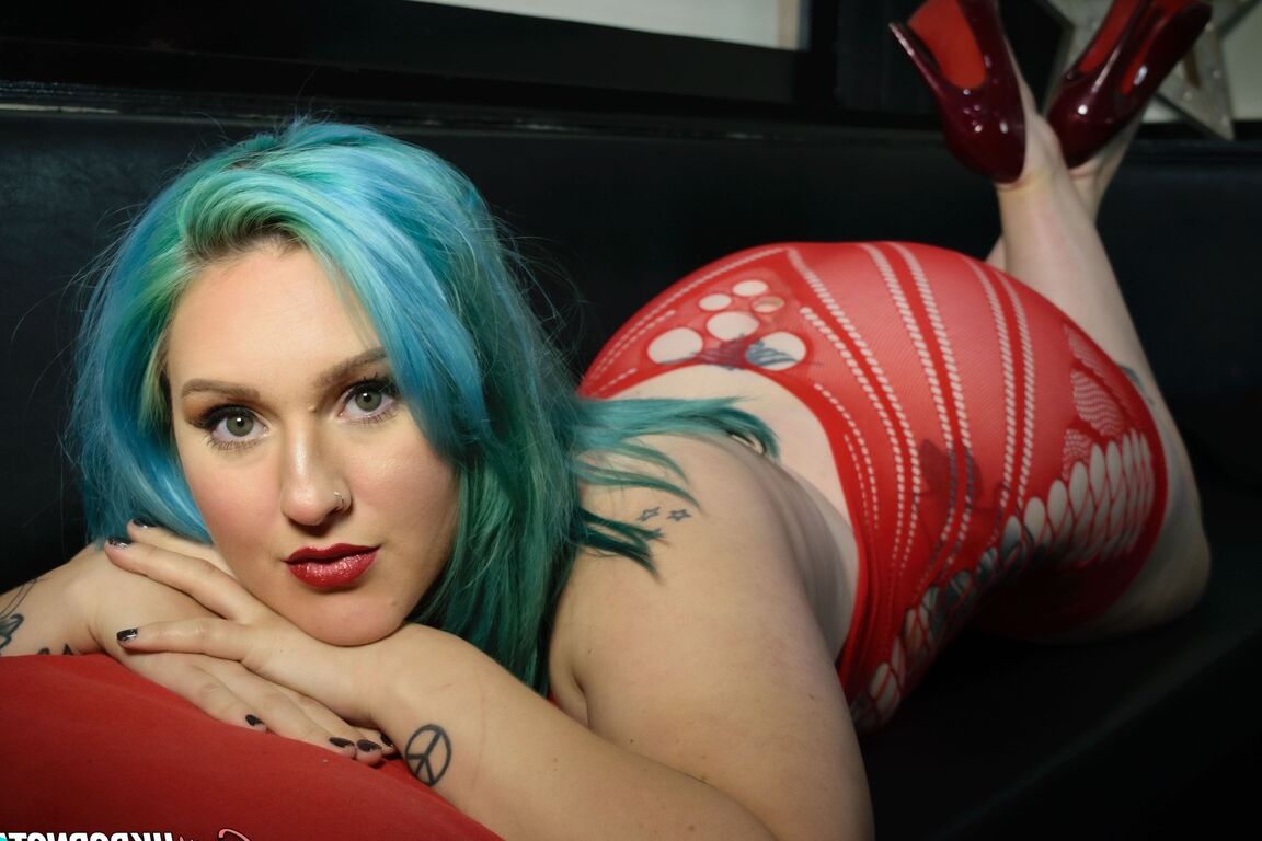 La star du porno britannique 16P Ruby Fall laisse ses tétons s'échapper d'une robe rouge révélatrice.