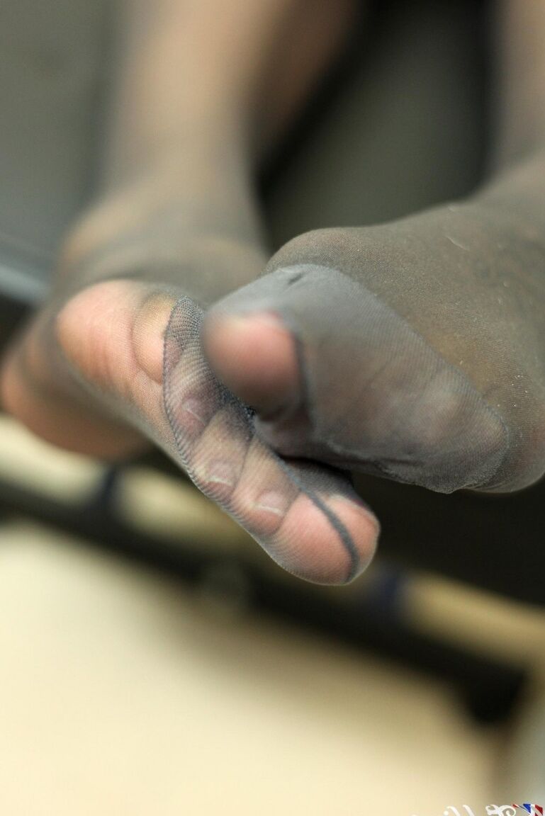 12P La alta chica negra Layla Brown se frota los pies cubiertos con pantimedias