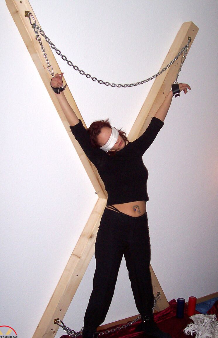 16P Blindfolded redhead Lilu Natilova is chained to a St Andrew's Cross