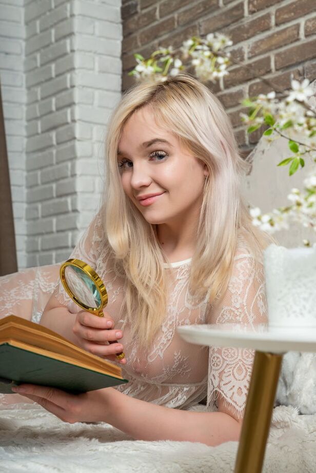 Die 18P junge, blonde Riya zieht sich in ihrem Schlafzimmer aus, während sie ein Buch liest