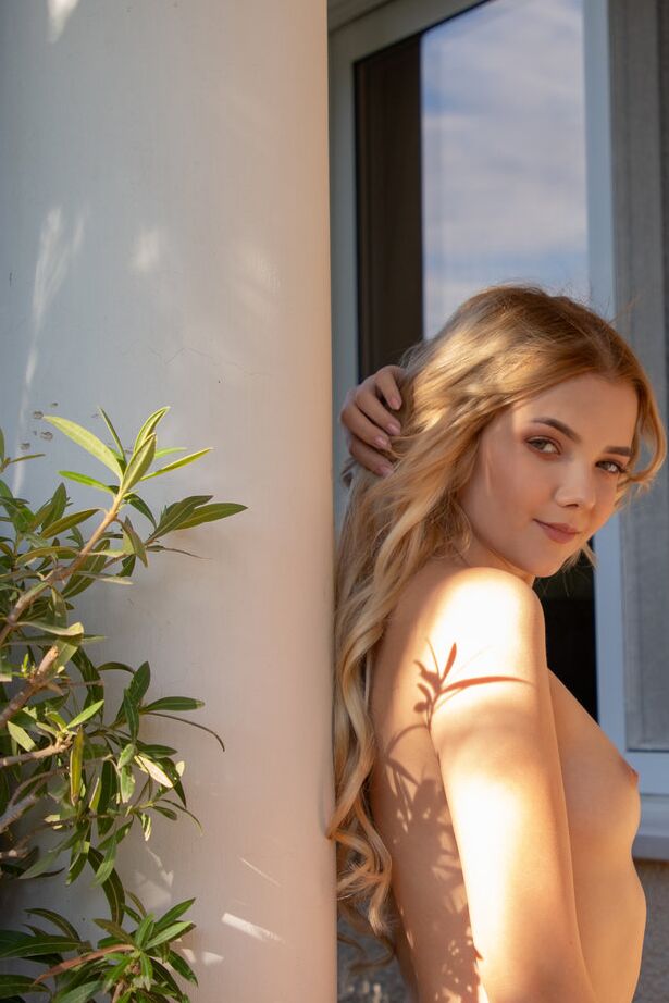 16P La joven rubia Chanel Fenn muestra su sexy culo mientras se desnuda en un jardín