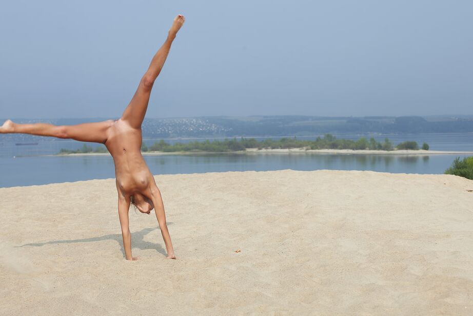 16P Loira flexível Afina meditando nua e se espreguiçando na praia