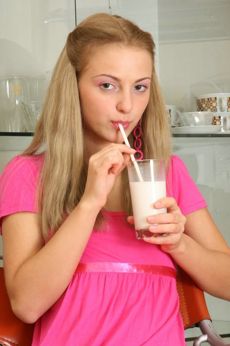 15P Junge Blondine trinkt ein Glas Milch, bevor sie in sexy Strümpfen mit ihrer Muschi spielt