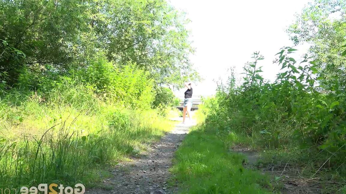15P European female Nikki Dream takes a piss while walking on a dirt path