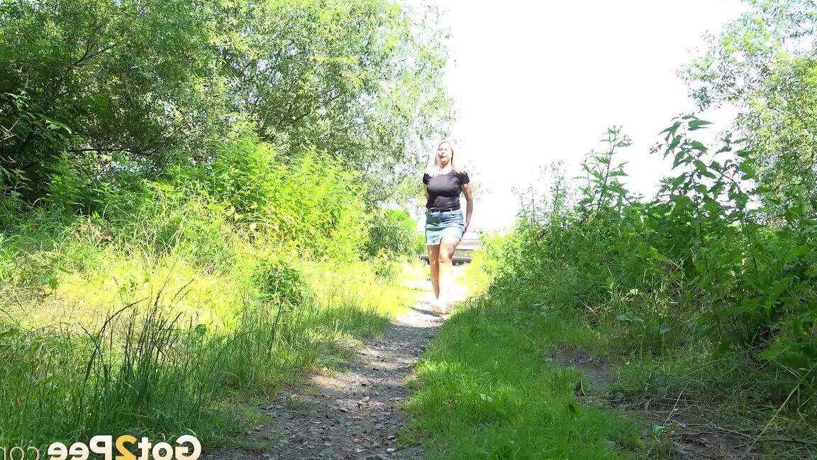 15P European female Nikki Dream takes a piss while walking on a dirt path