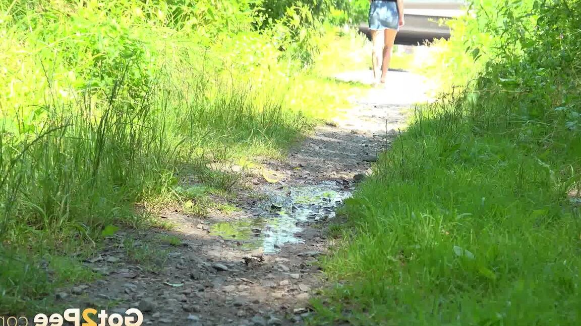 15P European female Nikki Dream takes a piss while walking on a dirt path