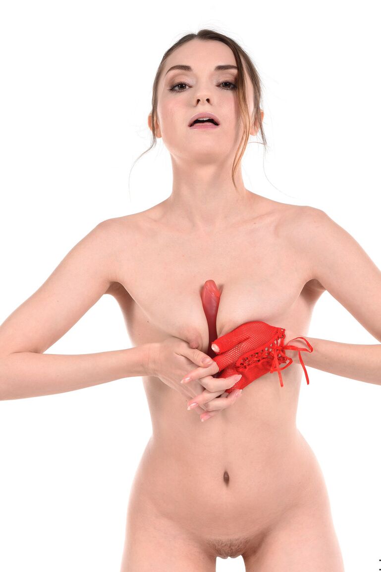 15P Sexy brunette Monika May sucks on a dildo after removing a red mesh bodysuit