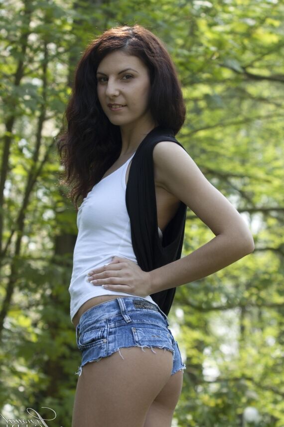 10P Chica morena delgada agarra una teta pequeña mientras se desnuda en la naturaleza