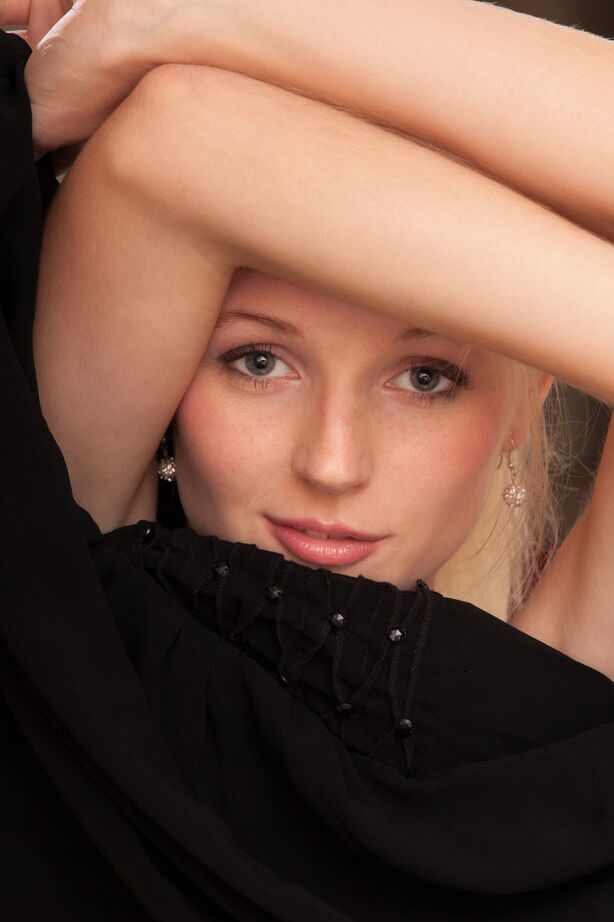 Leona Honey, jeune blonde et maigre, montre ses jambes sexy et sa chatte rasée.